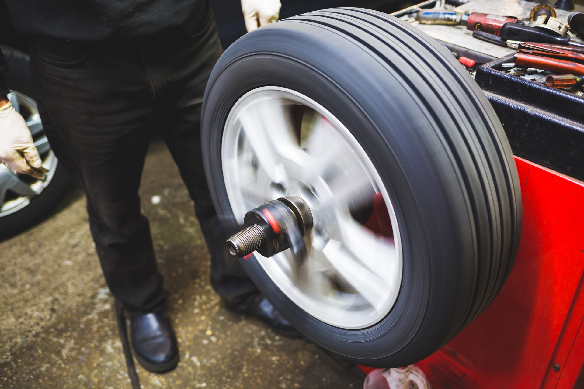 Mechanic aligning car tire at service